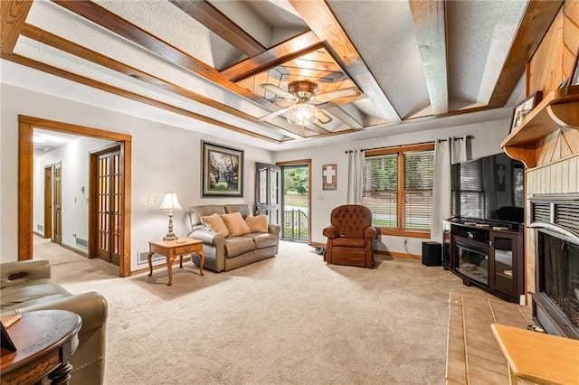 carpeted living room with ceiling fan and beam ceiling