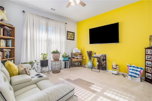 living room with ceiling fan and carpet