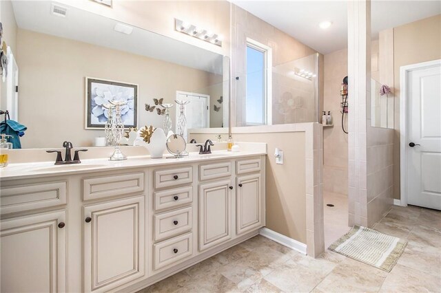 bathroom with vanity and a tile shower