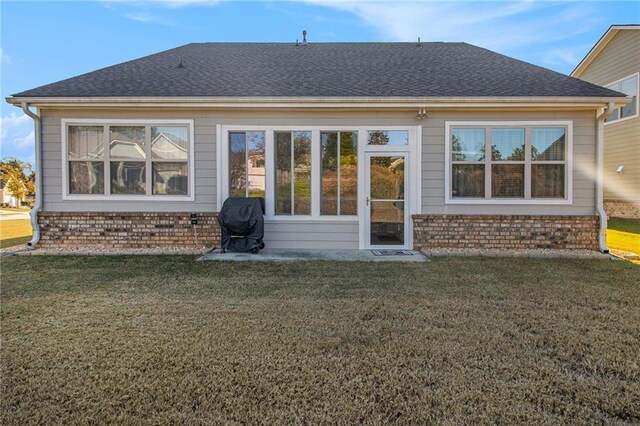 rear view of house featuring a yard