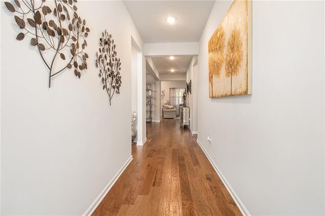 hallway with hardwood / wood-style flooring