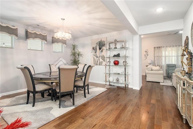 dining area with dark hardwood / wood-style flooring and a notable chandelier