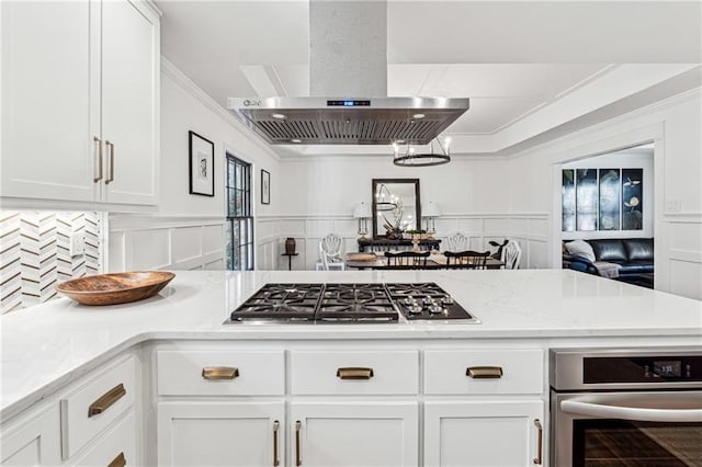 kitchen featuring range hood, stainless steel gas stovetop, white cabinetry, and crown molding