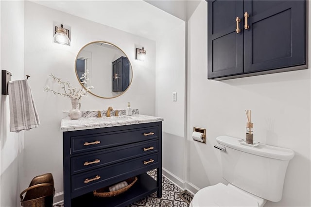 bathroom with toilet, baseboards, and vanity