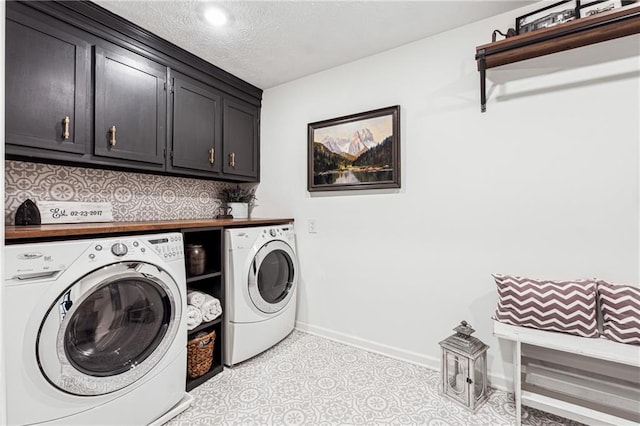 clothes washing area featuring baseboards, a textured ceiling, cabinet space, and washer and dryer