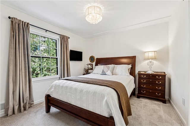 bedroom featuring light carpet, a notable chandelier, and baseboards