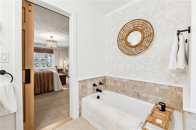 full bathroom featuring a garden tub, an inviting chandelier, ornamental molding, ensuite bathroom, and wallpapered walls