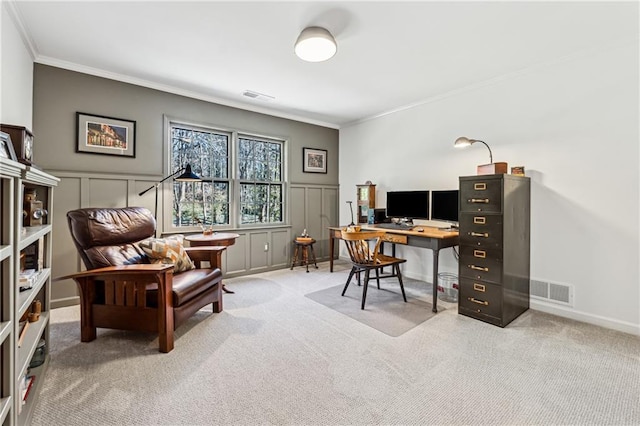 carpeted home office featuring ornamental molding, a wainscoted wall, visible vents, and a decorative wall