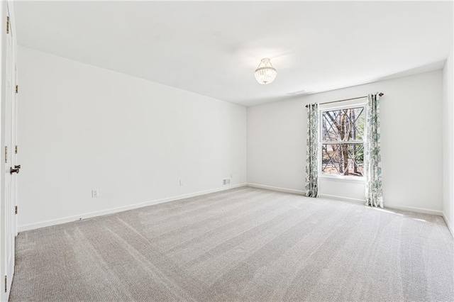 unfurnished room with light carpet and baseboards