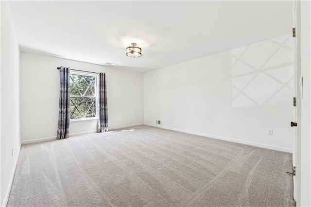 empty room featuring light carpet and baseboards