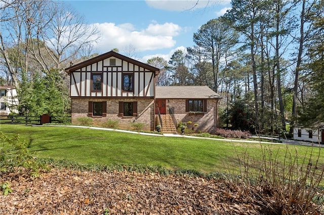 tudor house with stairs, a front lawn, and brick siding