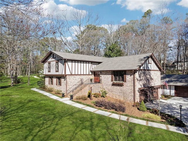 exterior space with driveway, a garage, roof with shingles, stairs, and a front lawn