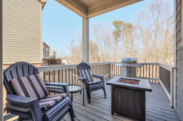 wooden terrace with grilling area and an outdoor fire pit