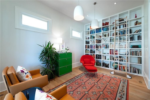 living area with recessed lighting, wood finished floors, and baseboards