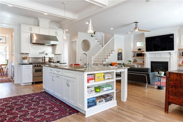 kitchen with open shelves, a sink, under cabinet range hood, high end stainless steel range, and crown molding