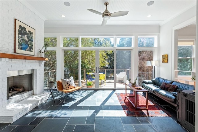 sunroom / solarium featuring french doors, a brick fireplace, and ceiling fan