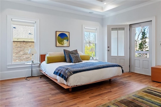 bedroom featuring recessed lighting, a raised ceiling, crown molding, and wood finished floors