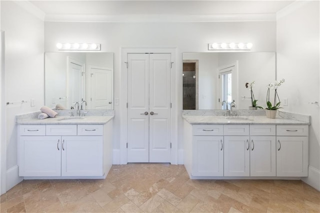 bathroom featuring a sink, two vanities, and crown molding