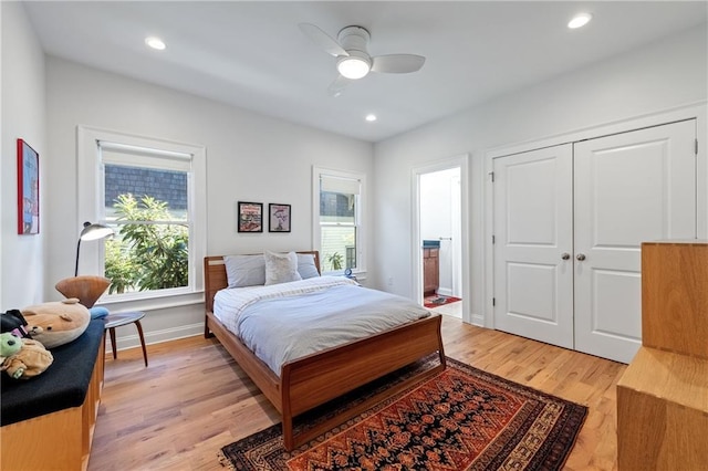 bedroom featuring recessed lighting, light wood-type flooring, baseboards, and ensuite bath