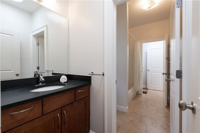 bathroom featuring vanity, baseboards, and shower / bath combo