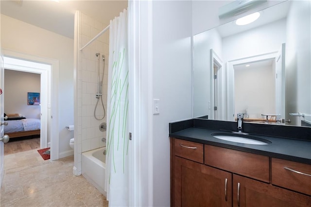 ensuite bathroom featuring connected bathroom, baseboards, toilet, shower / tub combo, and vanity