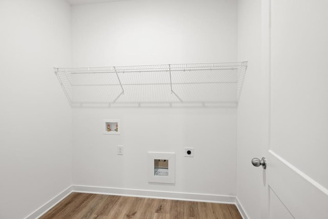 clothes washing area with washer hookup, electric dryer hookup, wood finished floors, laundry area, and baseboards