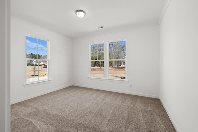 carpeted empty room featuring ornamental molding, visible vents, and baseboards