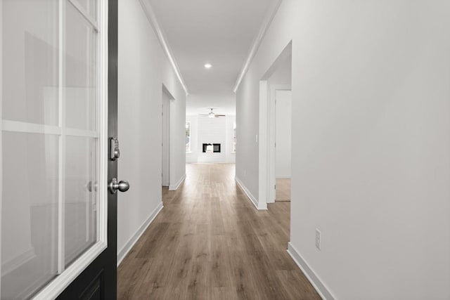 hall with ornamental molding, recessed lighting, wood finished floors, and baseboards