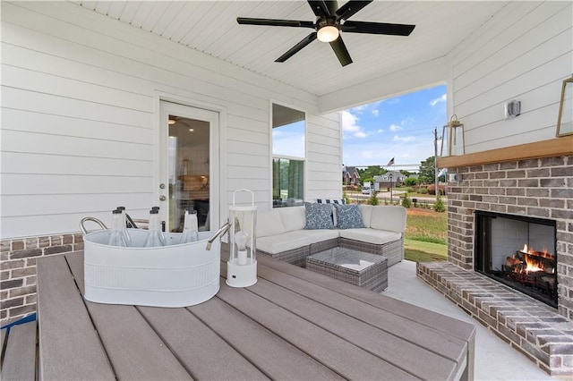 wooden terrace featuring a patio and an outdoor living space with a fireplace