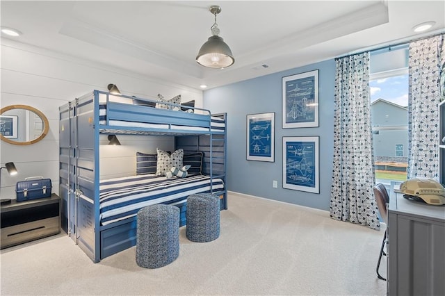 carpeted bedroom with crown molding and a raised ceiling