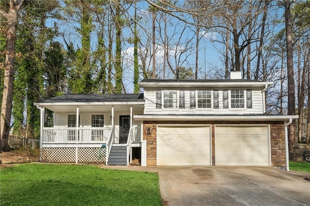 view of front of property featuring a garage, a front yard, and covered porch