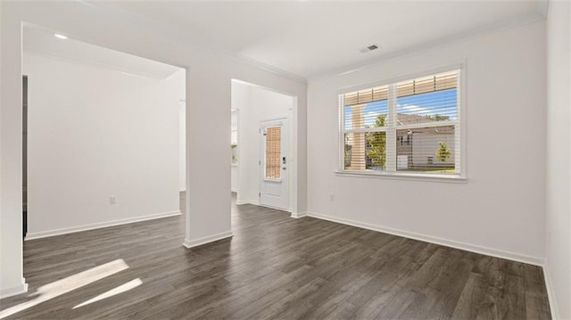 empty room featuring dark hardwood / wood-style floors and ornamental molding