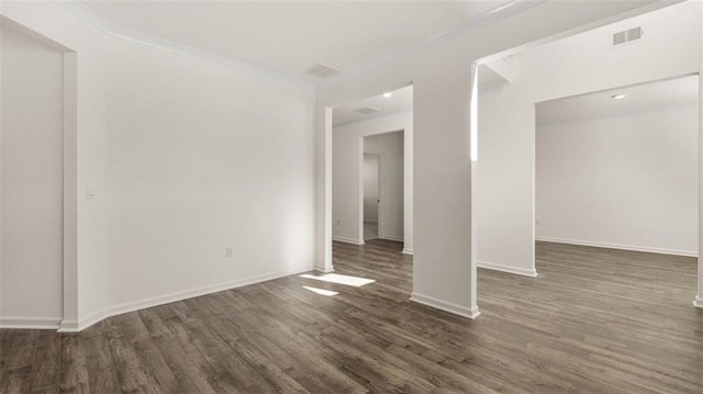 empty room with crown molding and dark wood-type flooring