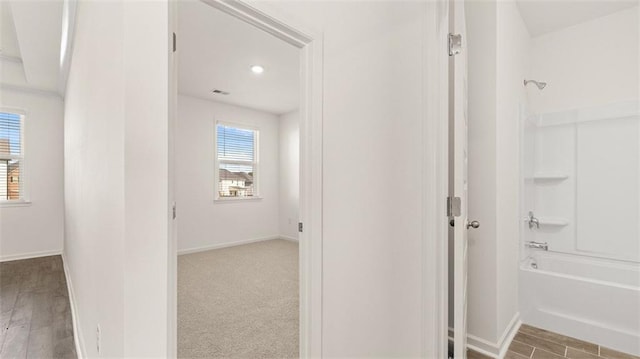 bathroom featuring hardwood / wood-style flooring, a healthy amount of sunlight, and bathtub / shower combination