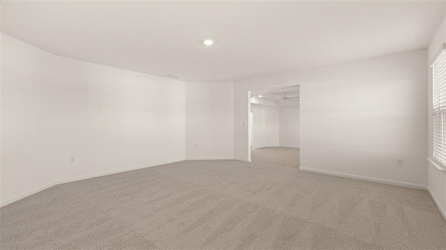 carpeted spare room featuring ceiling fan