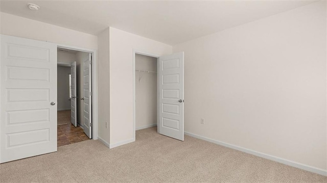 unfurnished bedroom featuring light colored carpet and a closet