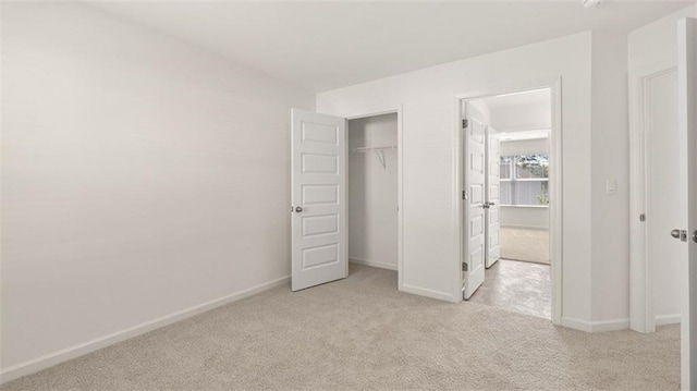 unfurnished bedroom featuring light carpet and a closet