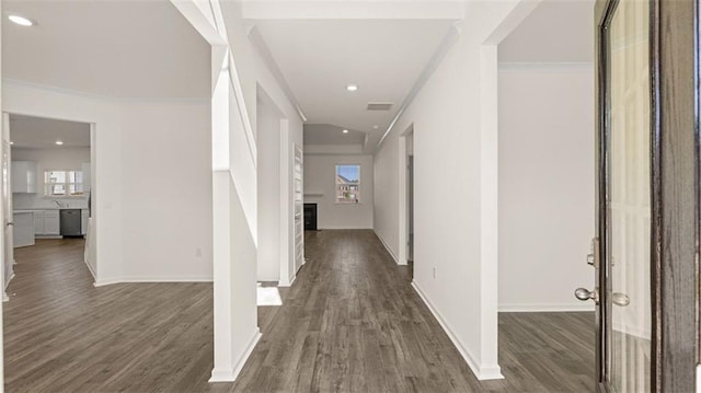 corridor with ornamental molding and dark wood-type flooring