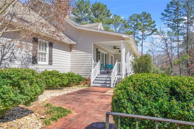 doorway to property featuring covered porch and ceiling fan