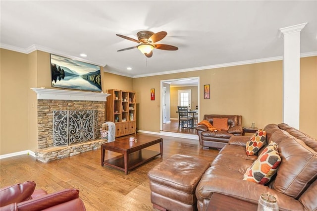 living area featuring a ceiling fan, wood finished floors, crown molding, decorative columns, and baseboards