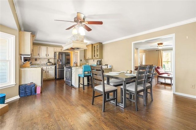 dining room with ceiling fan, crown molding, baseboards, and dark wood-style flooring