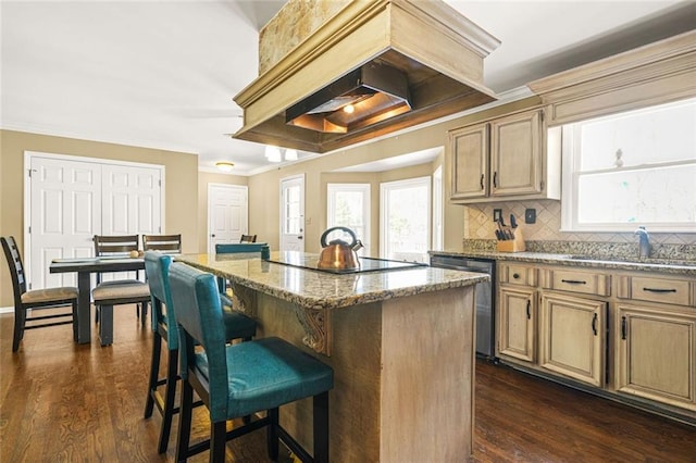 kitchen with dark wood-type flooring, a breakfast bar, stainless steel dishwasher, crown molding, and black electric cooktop