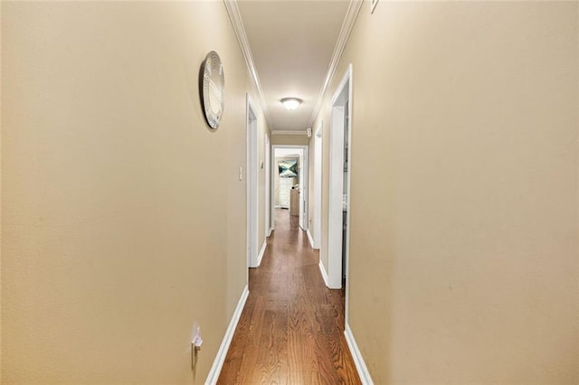 corridor with baseboards, crown molding, and dark wood-type flooring