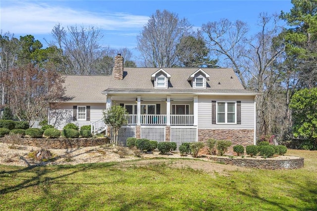 cape cod-style house with a front lawn, covered porch, stone siding, and a chimney