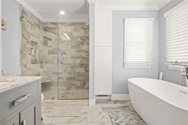 full bathroom featuring a shower stall, crown molding, baseboards, a freestanding bath, and vanity