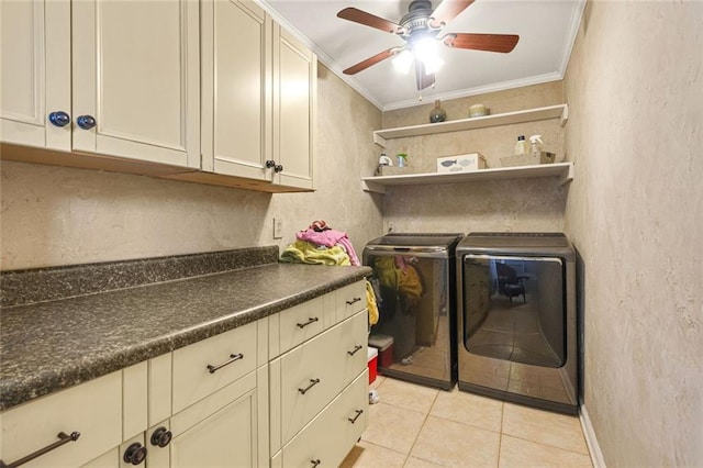 laundry room featuring light tile patterned floors, cabinet space, ornamental molding, a textured wall, and washer and clothes dryer