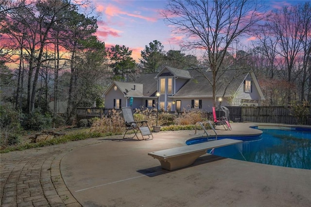 view of pool with a patio, a diving board, fence, and a fenced in pool