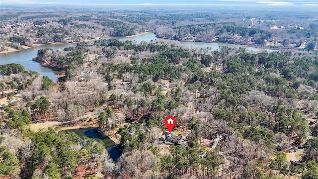 birds eye view of property with a water view and a wooded view