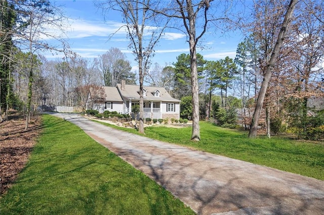 view of front facade with a front lawn, driveway, and a chimney