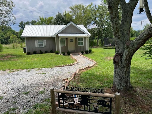 view of front of house featuring a trampoline and a front lawn